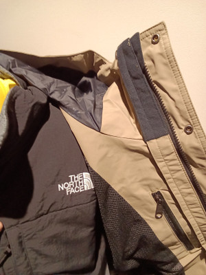 ノースフェイス（THE NORTH FACE）のマウンテンジャケットの前ファスナーを開け、内側の構造を見せているクローズアップです。