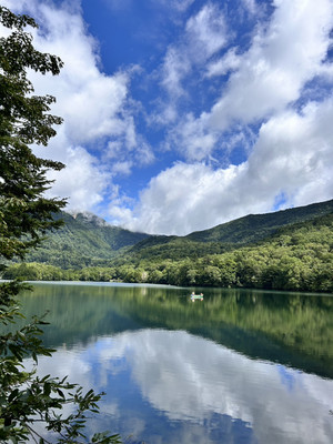 奥日光の青空と白い雲を映す静かな湖と、緑豊かな山々が広がる夏の風景