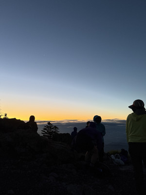 夜明け前の男体山山頂で登山者が日の出を待つ幻想的な風景